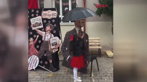 Atatürk maketini yağmurdan şemsiyeyle korudu