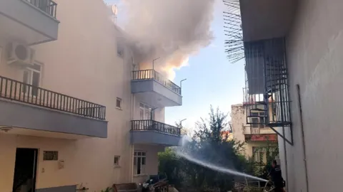 Evde çıkan yangında mahsur kalan kediyi balkona tırmanıp kurtardı